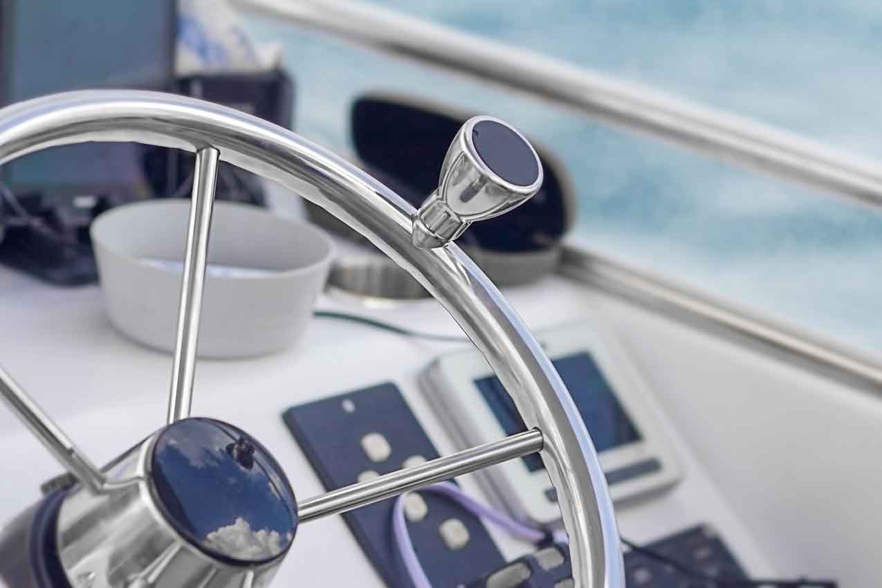 Round metal steering wheel of a small electric rental boat, close up