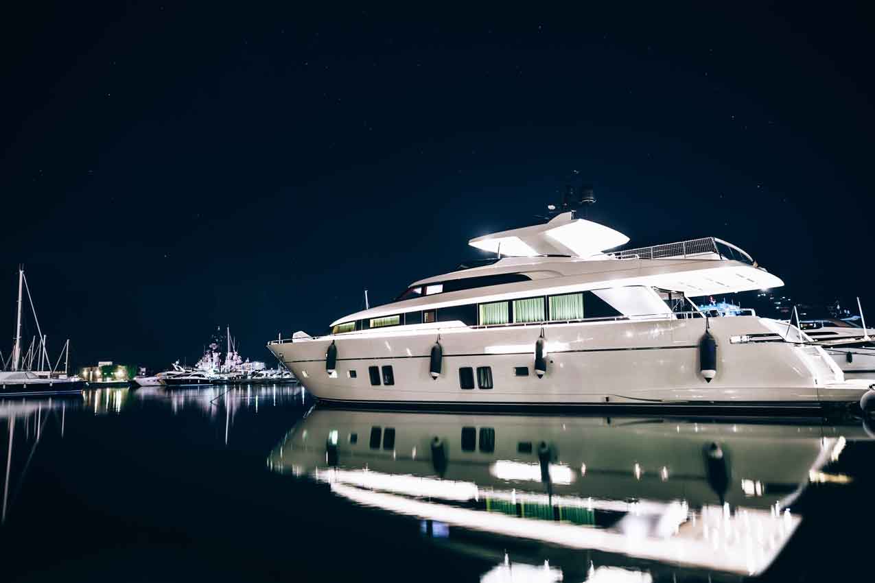 Luxury yachts in harbor at night reflected on the water