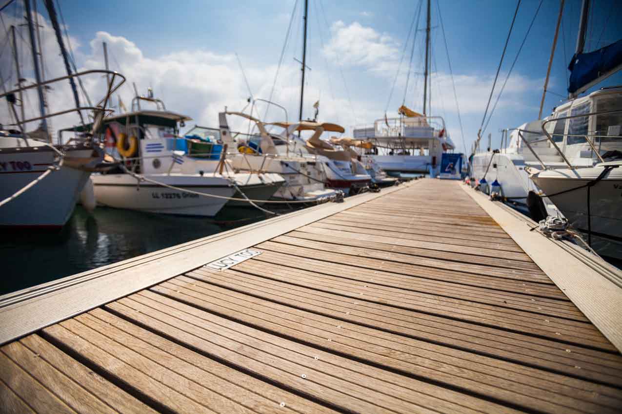 group of anchored boats on a marina on wooden pier