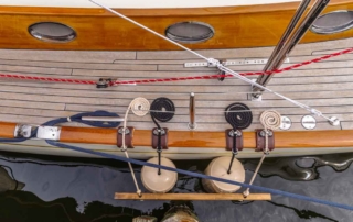 Overhead medium close-up detail of starboard hull, deck, lines and brightwork