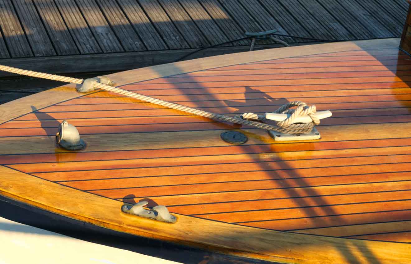 Freshly varnished boat at a wooden dock in harbor