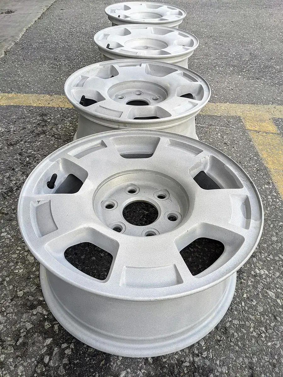 A wheel being dustless blasted, with bare metal showing through the old finish.